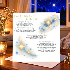 open window with a blue starry sky - a card siting on a white envelope with andles and a soft muted home setting