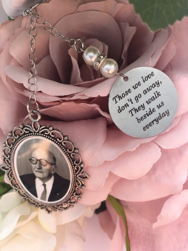 pink flowers with pearl charms with writing and picture of a man inside a pendant