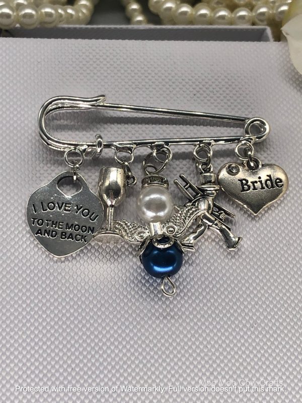 5 silver charms on a kilt pin