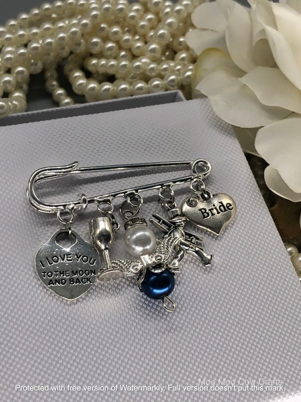 5 silver charms on a kilt pin with pearls