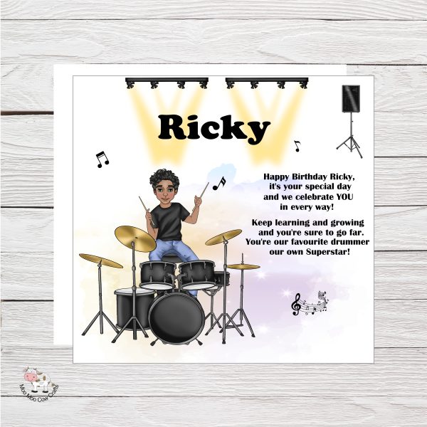 wooden background with clipart image of a drummer on a white background with spot lights, it's a birthday card