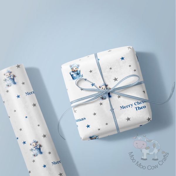 blue background with a wrapped gift and a roll of wrapping paper in a blue teddy design.