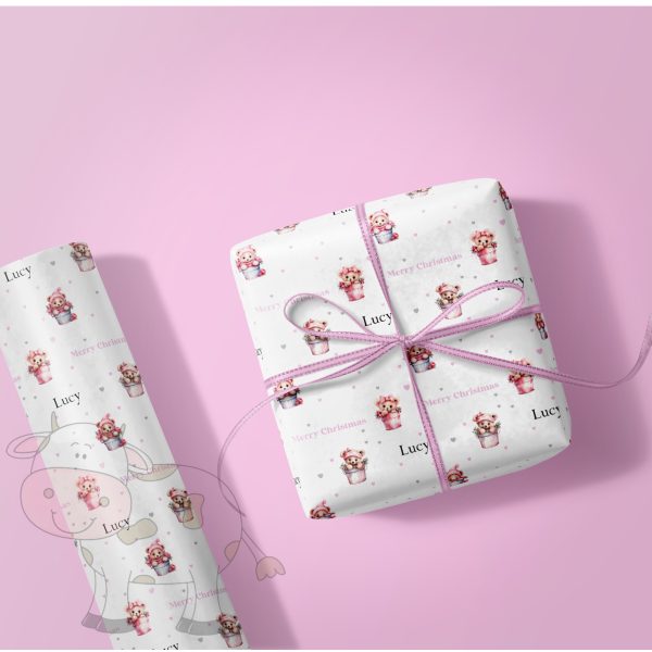 wrapped gift and a roll of gift wrap with a pink background and a pink teddies design.