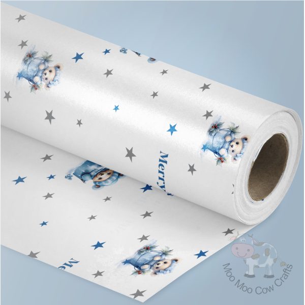 blue background with a roll of wrapping paper with a blue teddy bear design
