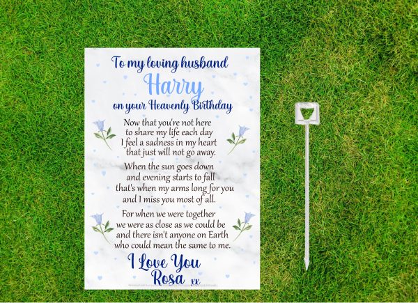 grass background with white card with black and blue writing, it's a grave card