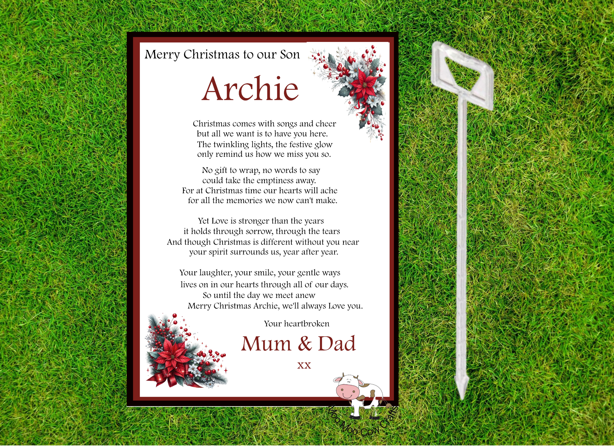grass background with a white rectangle with rustic red flowers and text, it's a memorial card for a grave.