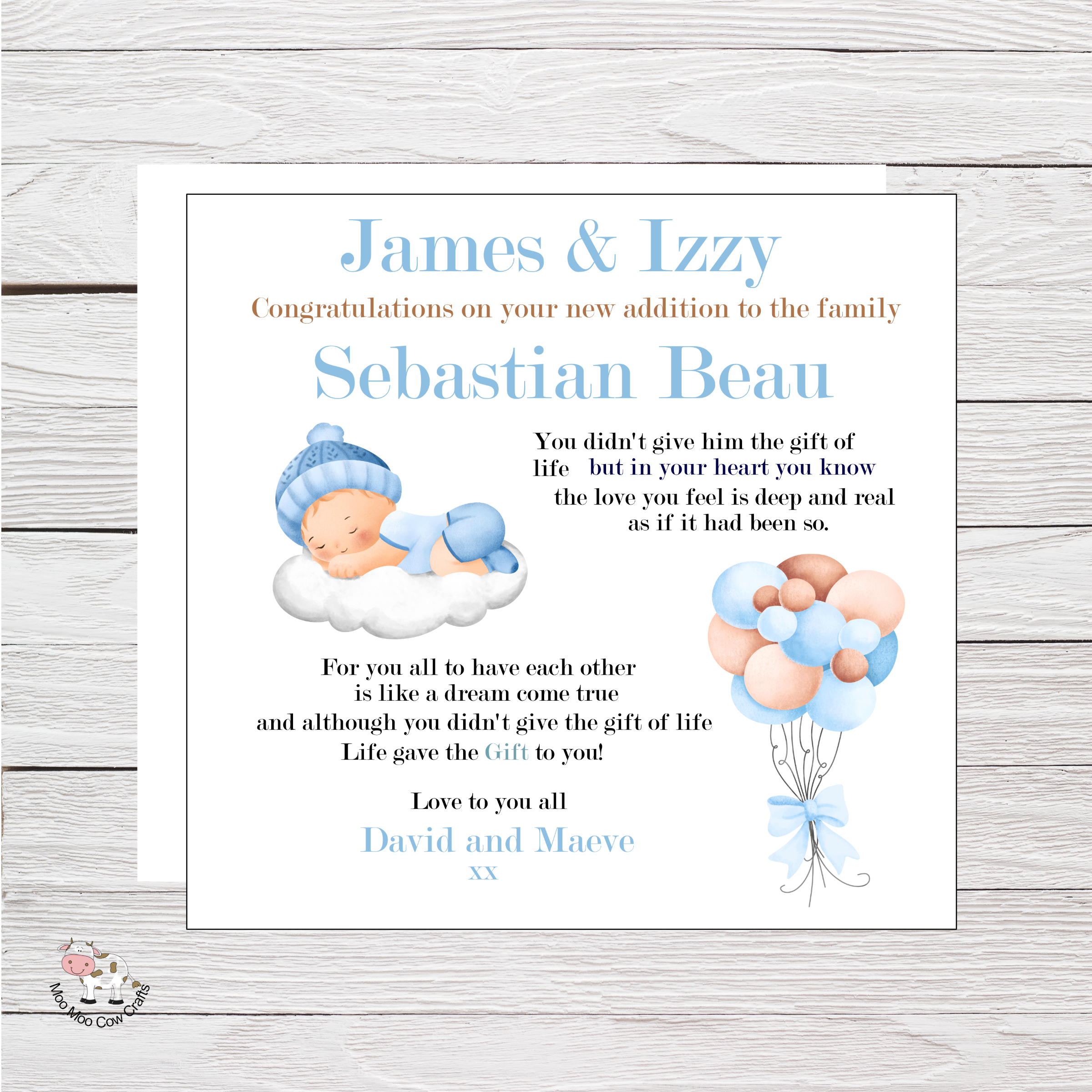wooden background with clip art image of a baby boy sleeping on a cloud and blue and brown balloons - it's a celebration card for a new baby