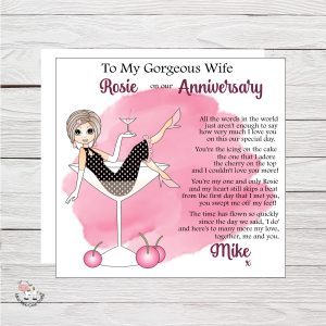 wooden background with clip art image of a lady sitting in a cocktail glass with cherries - it's an anniversary card