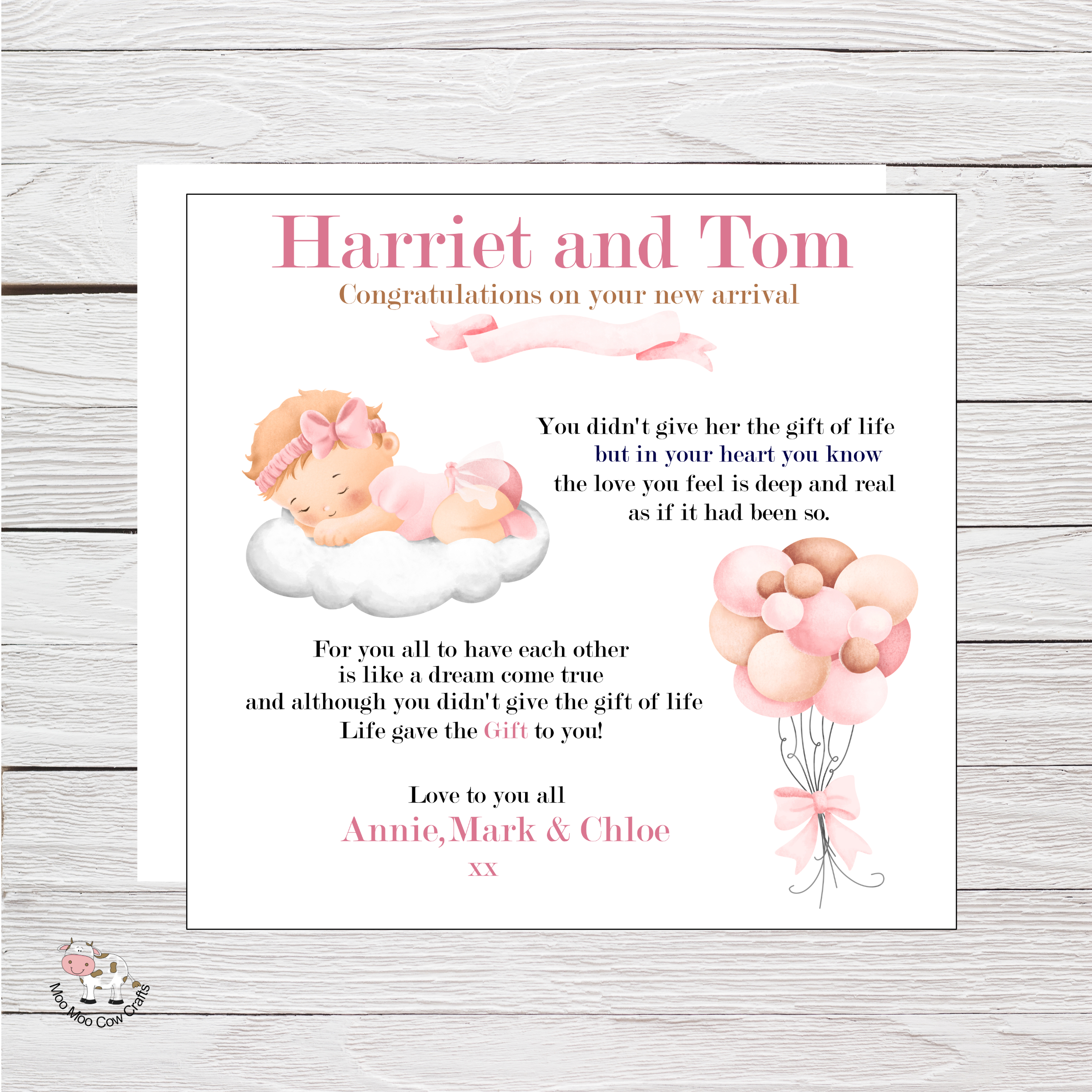 wooden background with clip art image of a baby in pink headband lying on a cloud. Pink and brown balloons and black and pink text - it's a congratulations card for a new baby that has been adopted.