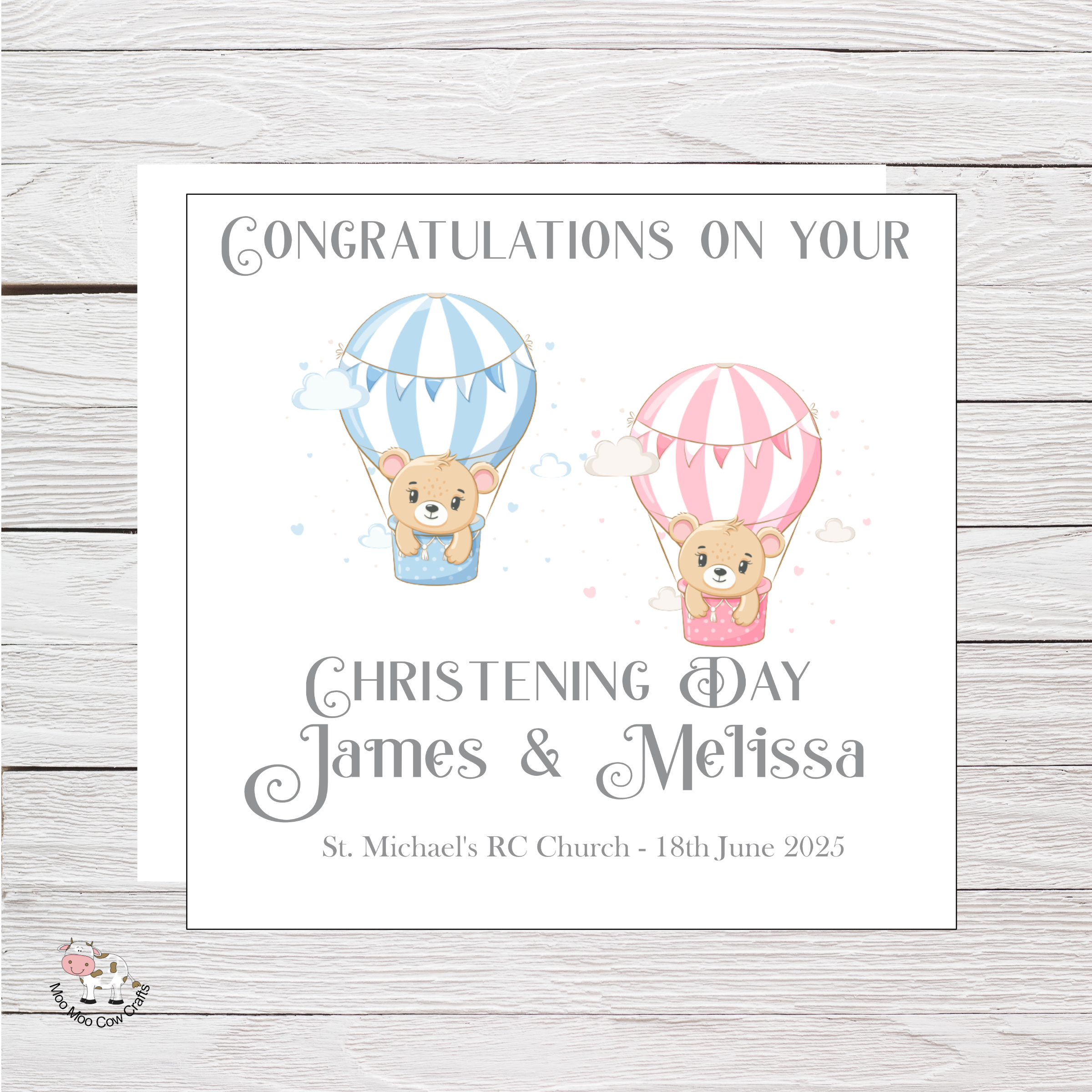 wooden background with a white card, two clip art balloons one pink and one blue, it is a christening card for twin babies.