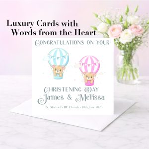 pastel background with a vase of pink and white flowers with a card standing on an envelope, the card has two clip art bears in balloons, one pink and one white. It is a christening card for twin babies.