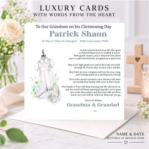 Personalised religious Christening card with baby romper design, displayed with white flowers and a wooden cross.